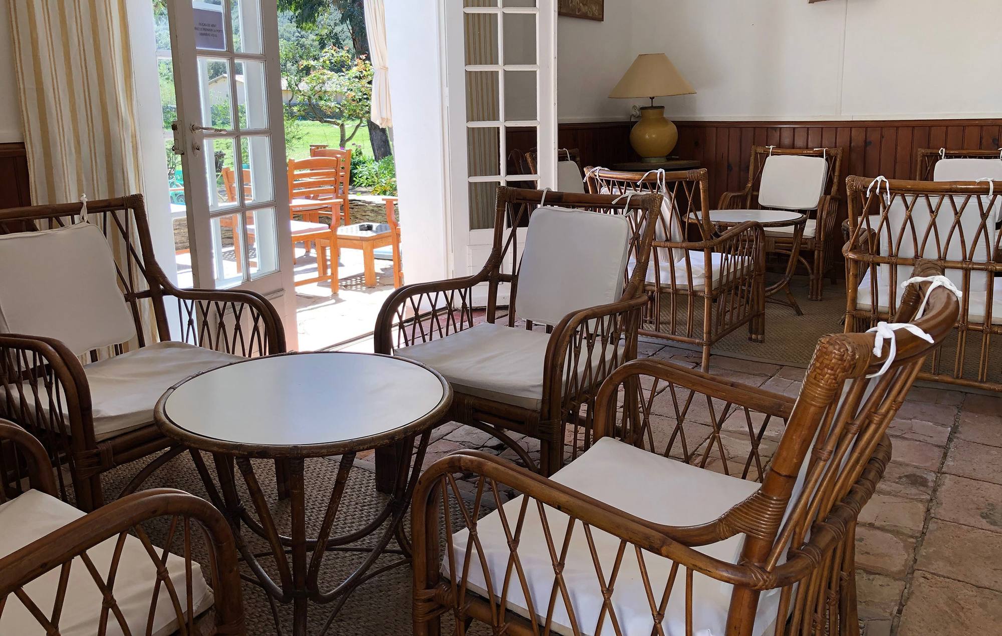 Salon en rotin du bar du Manoir, ouvert sur le jardin